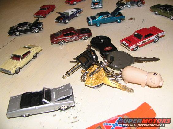 Collection of toy cars and a keychain with a pig charm and car keys