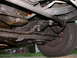 1987 Lincoln Town Car - The underside of the vehicle is heavily coated in oil, obscuring many of the mechanical components.