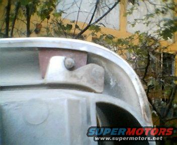 Close-up of a metal vehicle part with a bolt and bracket