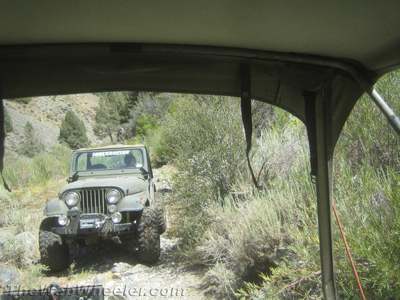Olive green Jeep CJ-5 with winch on a rocky trail