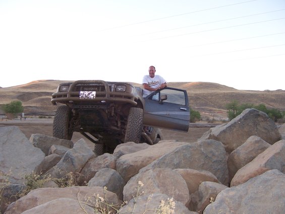 Gray SUV with open door on rocks