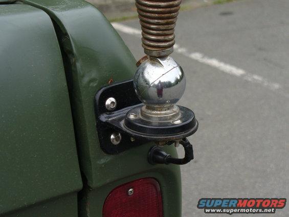 CB antenna mount on rear corner of green vehicle