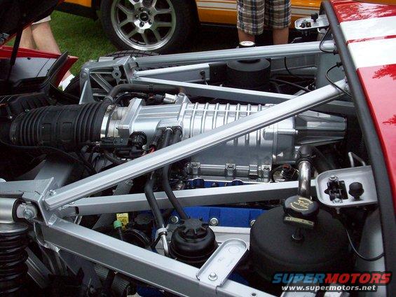Supercharged engine bay with silver supercharger and red body panels
