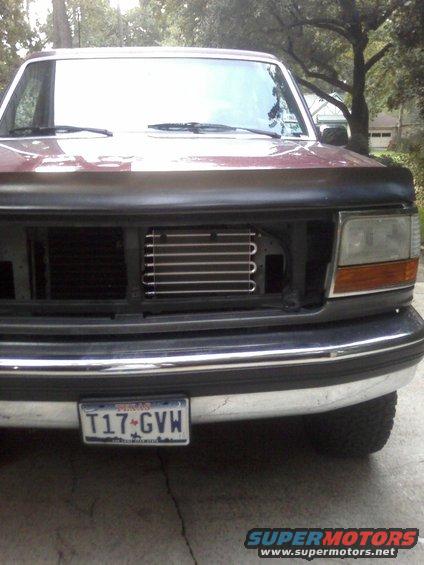1992 Ford Bronco front end showing grille, headlights, bumper, and aftermarket transmission cooler. Texas license plate T17-GVW