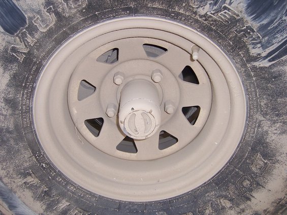 Close-up of a dusty wheel and tire with a manual locking hub