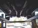 1978 Ford Mustang II - The undercarriage of a 1978 Ford Mustang II is visible as it is raised on a service lift.