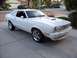 1978 Ford Mustang II - A white coupe with distinctive rear window louvers is parked in a suburban driveway.