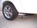 1978 Ford Mustang II - Close-up view of a white car's rear wheel and chrome exhaust tip.