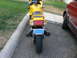 2002 Kawasaki Ninja - A yellow motorcycle is parked next to a red car, showing its rear end and license plate.