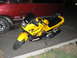2002 Kawasaki Ninja - A yellow 2002 Kawasaki Ninja motorcycle is parked next to a red van.