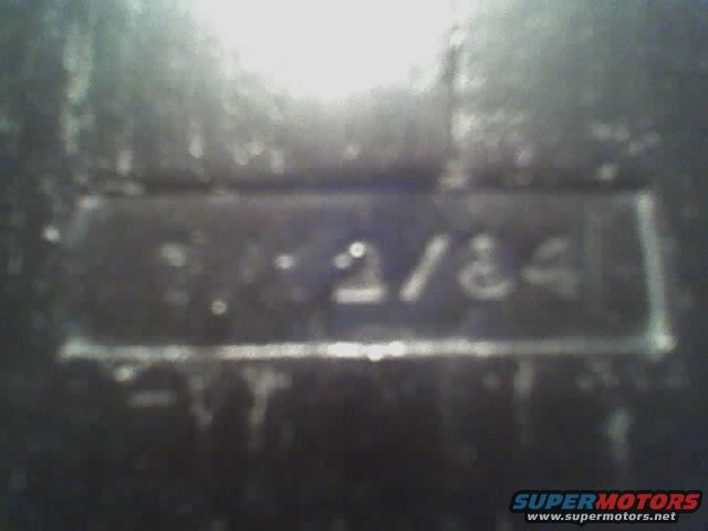 Close-up of a metal plate with "11-2/84" stamped on it
