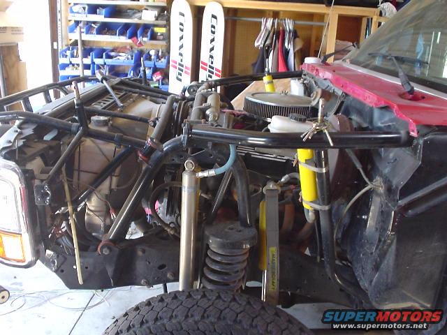 Modified 1980s Ford Bronco front end with roll cage and exposed engine components