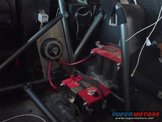 Interior view of dual batteries and a battery disconnect switch with red wiring