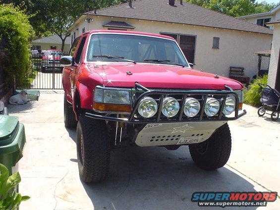 Red SUV with off-road lights and bumper, license plate 4JXJ895