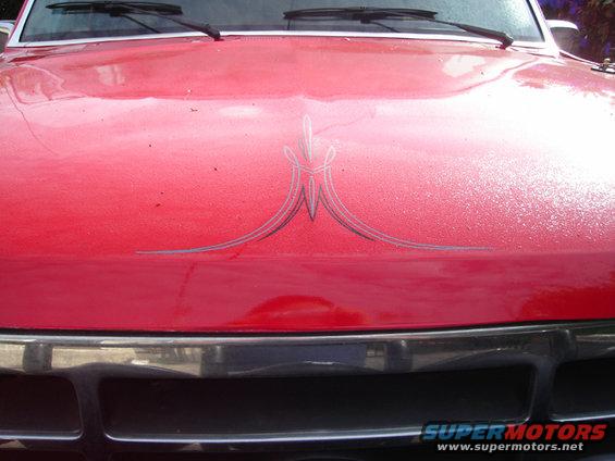 Red truck hood with silver pinstripes and chrome grille