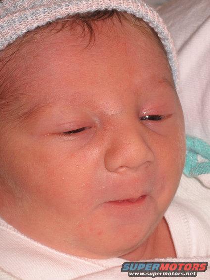 Newborn baby wearing a hospital hat