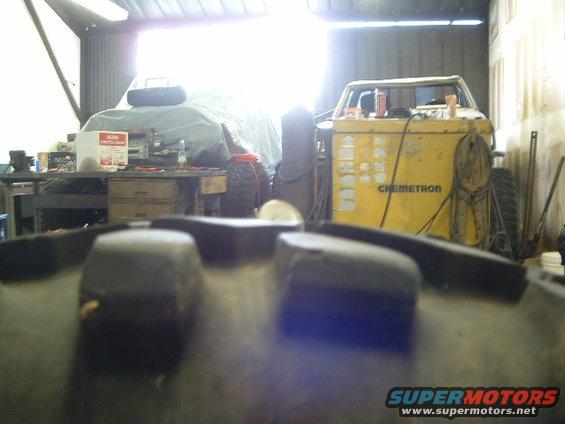 Jeep CJ-7 interior, close-up on dashboard and windshield frame, with a yellow Chemtron machine in the background