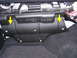 2007 Mazda 3 - This image shows a black plastic fuse box cover inside a vehicle, with yellow arrows indicating attachment points.