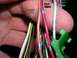 2007 Mazda 3 - A hand holds a bundle of electrical wires, some labeled with color combinations, suggesting a wiring harness or connection point of electri…