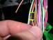 2007 Mazda 3 - Close-up of a hand and a wiring harness with multiple colored wires.