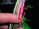 2007 Mazda 3 - A hand holds a wiring harness, with labels indicating specific wire colors for reference.