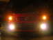 2007 Mazda 3 - A red Mazda 3 is parked at night with its lights illuminated.