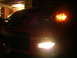 2007 Mazda 3 - The front of a red 2007 Mazda 3 is visible at night, with its headlights and fog lights illuminated.