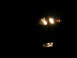 2007 Mazda 3 - Front view of a 2007 Mazda 3's illuminated headlight and fog light in the dark.