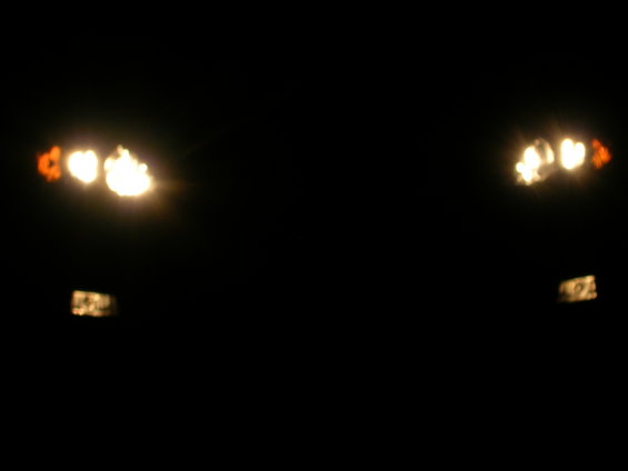 Headlights and amber fog lights illuminated at night, viewed from the front