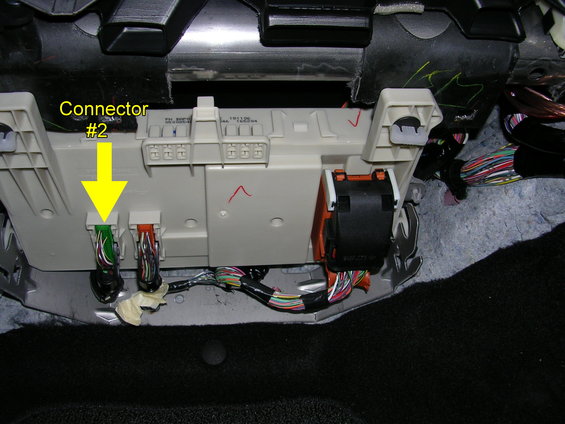 Vehicle interior wiring harness connectors labeled 'Connector #2' with a yellow arrow pointing to green and orange plugs