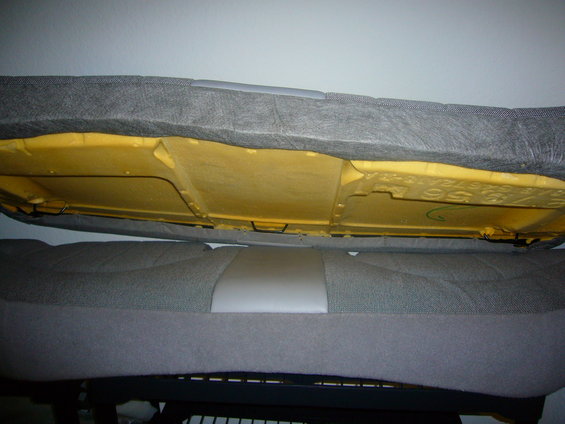 Underside of car seat with yellow foam padding