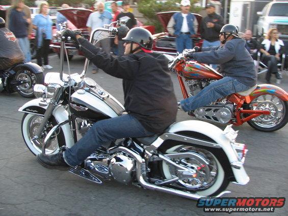 Two guys on motorcycles, one white and chrome, the other orange with custom paint