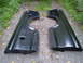 1979 Ford Bronco - These are two black truck bedsides, likely for a pickup truck, shown from a side angle on a gravel surface.