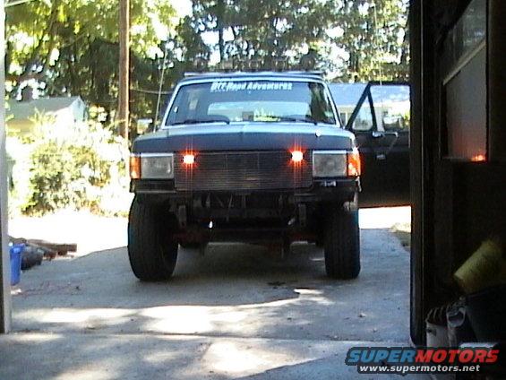 1990 Ford Bronco parked in driveway, front view, orange marker lights on
