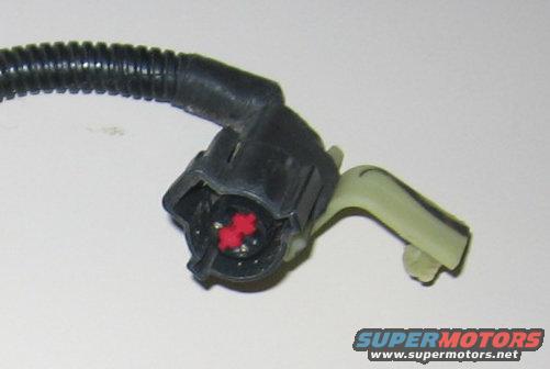 Electrical connector with red inserts and black ribbed wire loom