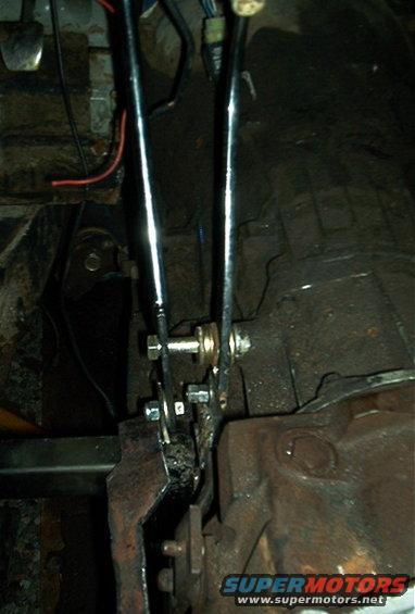 Close-up of linkage mechanism and transmission housing inside a vehicle