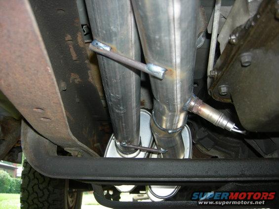 Dual exhaust pipes with oxygen sensor and Supermotors.net logo