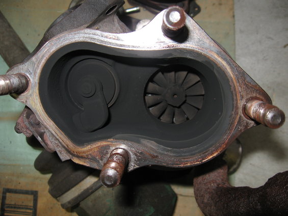 Close-up of a turbocharger's internal components, showing the turbine wheel and wastegate