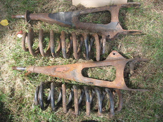 Pair of rusty front suspension control arms with coil springs