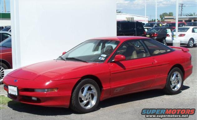 Red 1996 Ford Probe GT parked on asphalt with other cars in background