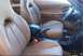 1996 Ford Probe - The interior of a car shows tan leather seats, a center console with a gear shifter, and the steering wheel.