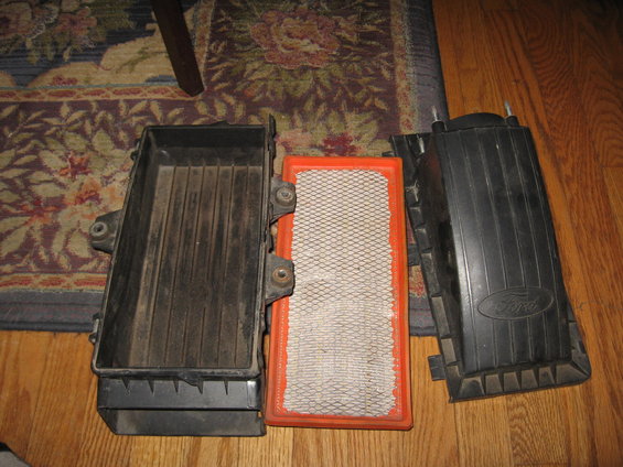 Ford Bronco air cleaner housing disassembled with filter. Ford logo visible on one part
