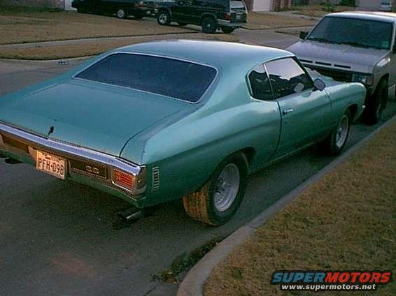 Teal coupe rear view, license plate PFN-098. Other vehicles visible