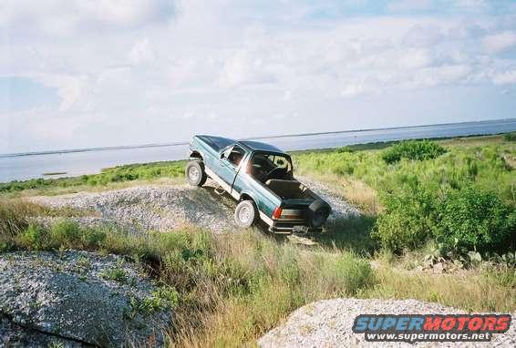 Ford pickup truck on a dirt hill near water