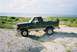 1990 Ford Bronco - This Ford Bronco is parked off-road near a body of water.