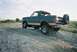 1990 Ford Bronco - This Ford Bronco is parked on a gravel incline with a body of water and vegetation in the background.