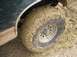 1990 Ford Bronco - The vehicle's tire and fender are heavily covered in mud, suggesting off-road use.