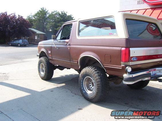 Brown 1990 Ford Bronco rear quarter view with tan top
