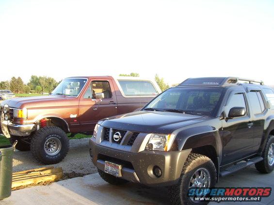 1990 Ford Bronco and a dark Nissan Xterra parked outdoors