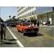 2007 Ford Ranchero - Classic red car with hood scoop in a street scene with other vehicles and pedestrians.